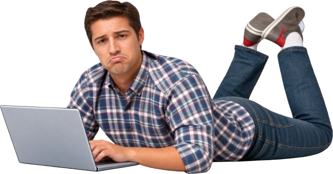 Een man ligt op zijn buik achter zijn laptop en kijkt teleurgesteld